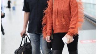 65岁赵雅芝穿橙SE羽绒服，墨镜抹红唇，走在机场被丈夫陪伴